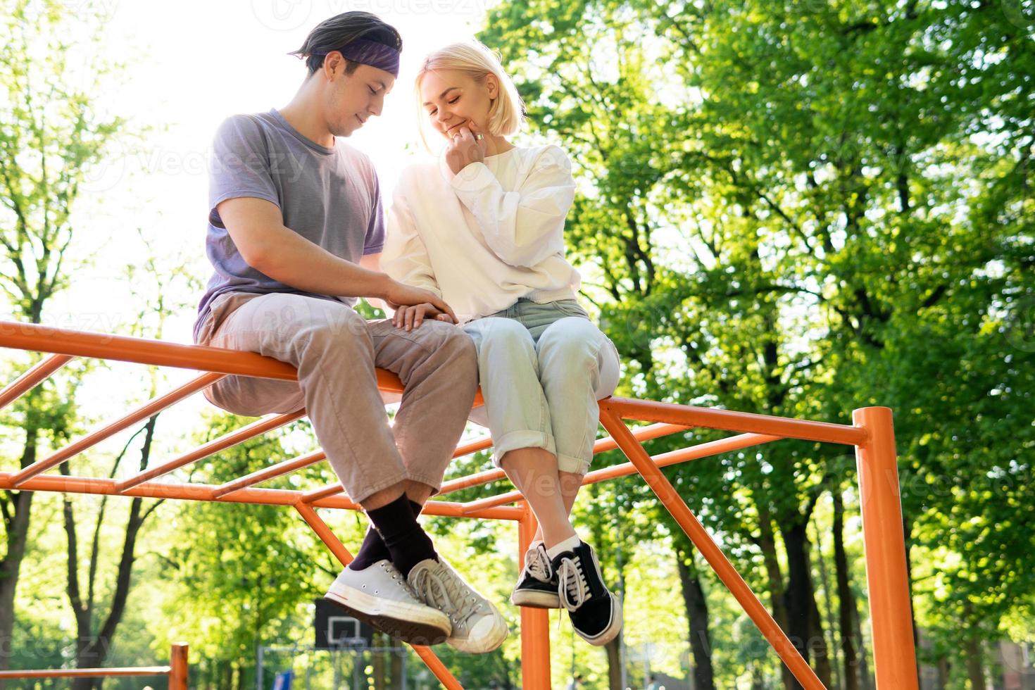 Happy teen couple on playground in a city park photo