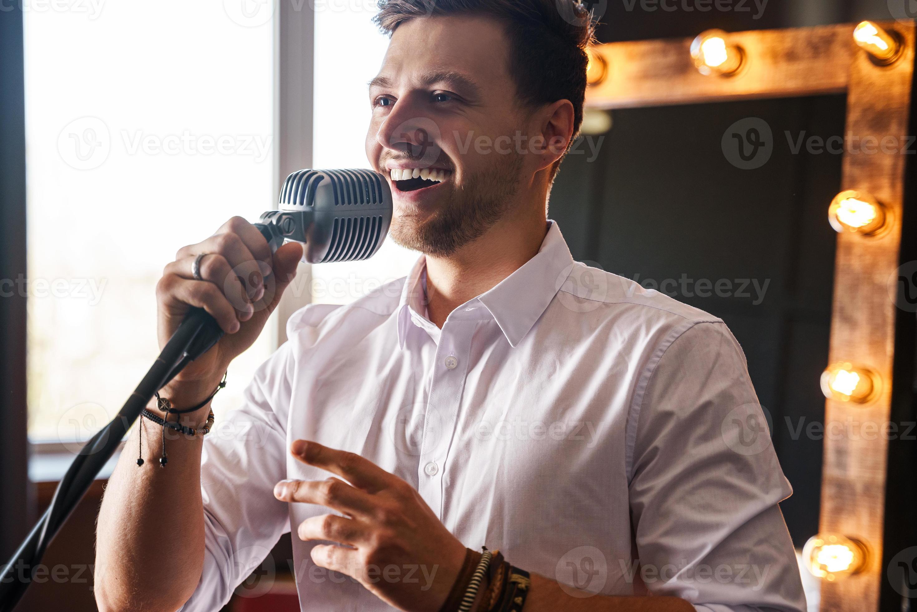 Young smiling man with microphone is singing at home 14405950 Stock