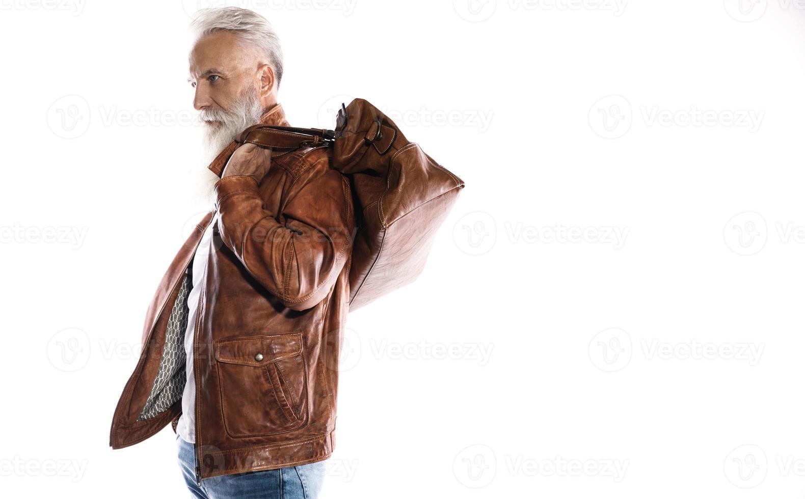 Handsome bearded senior man with leather bag and jacket on white background photo