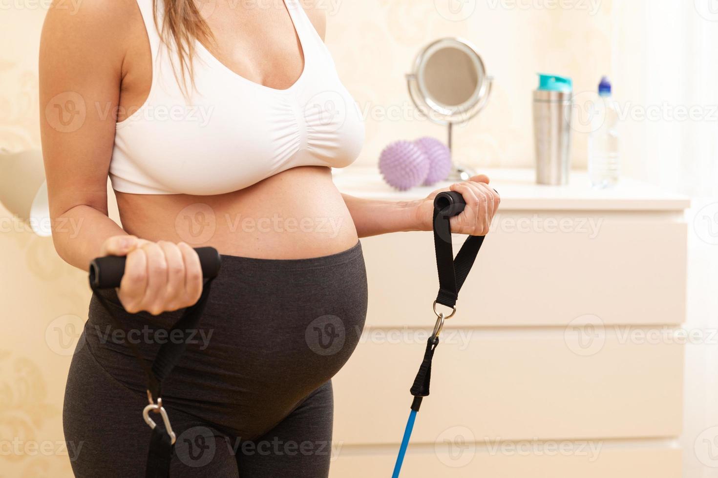 Pregnant woman during her fitness workout at home photo