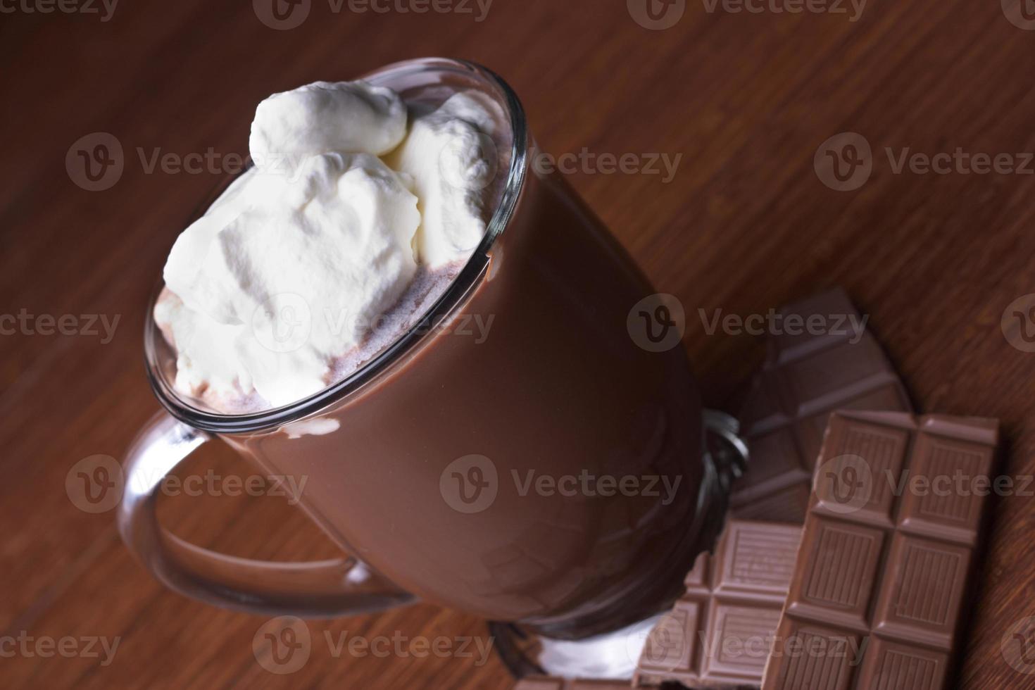 chocolate caliente en una taza de vidrio con crema limpia foto