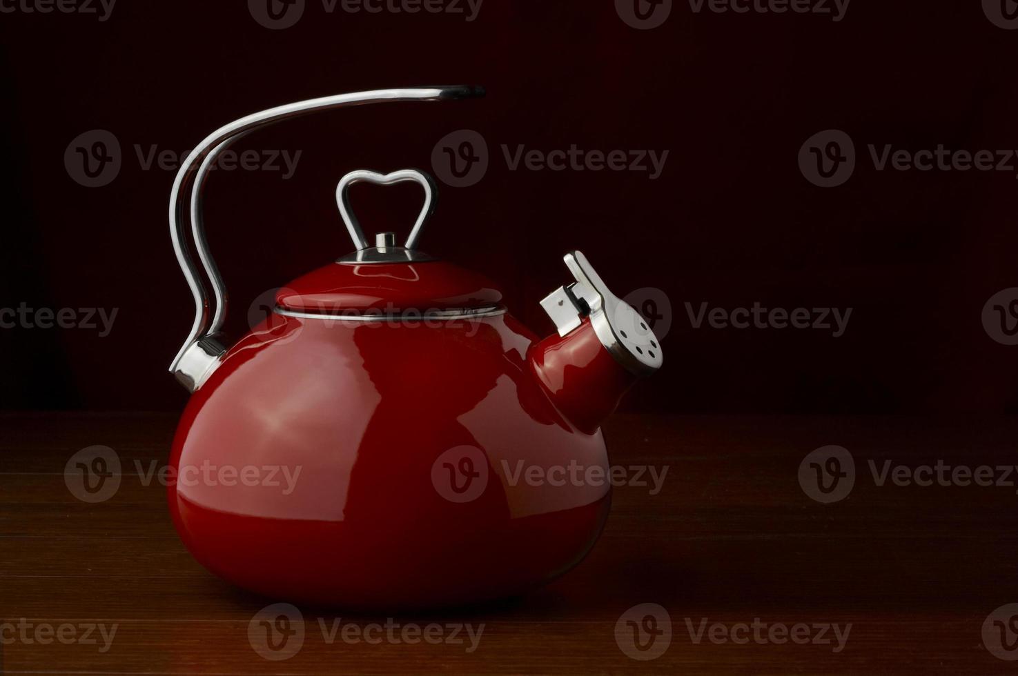 a red kettle on a dark background photo