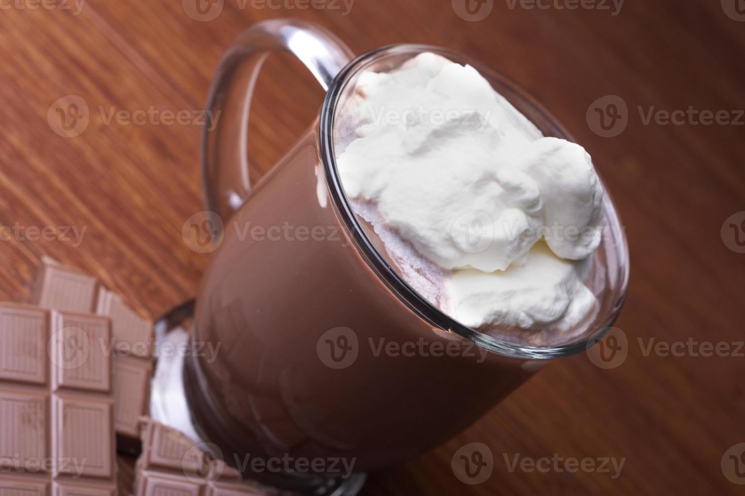 chocolate caliente en una taza de vidrio con crema limpia foto