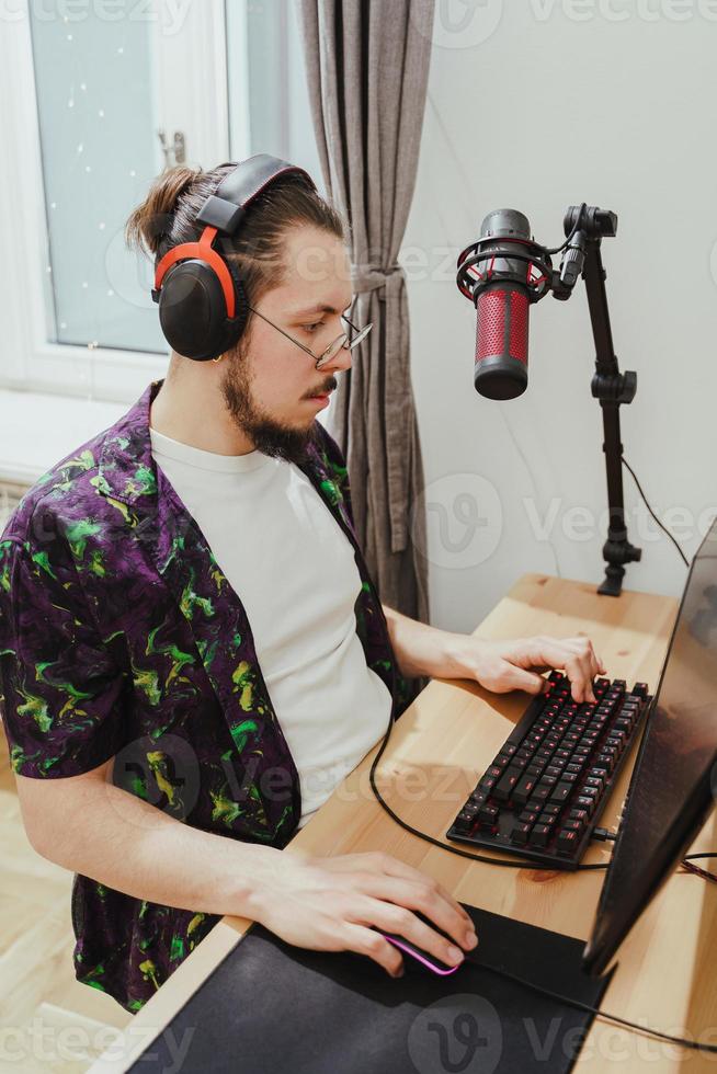Young man gamer playing video game on his modern personal computer photo