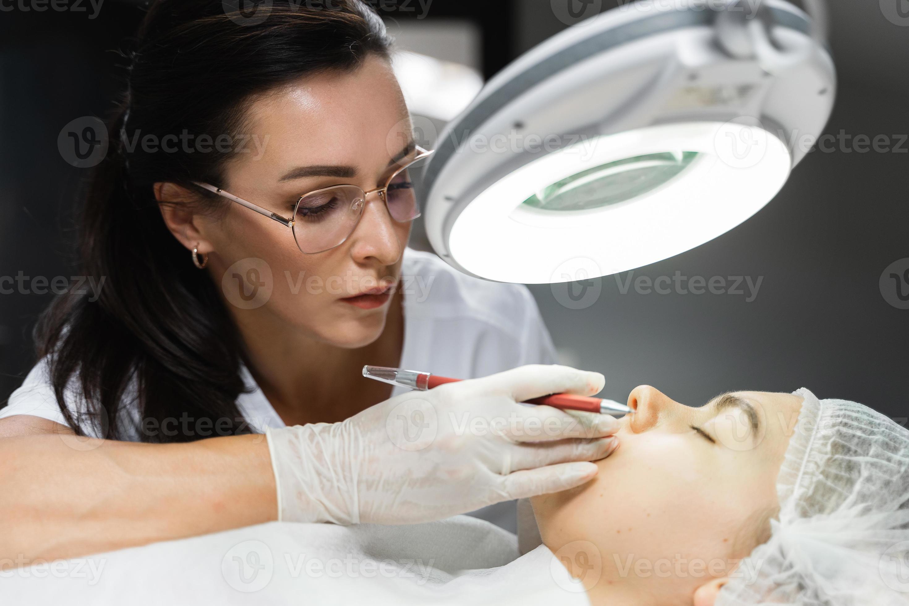 Permanent makeup artist and her client during lip blushing procedure