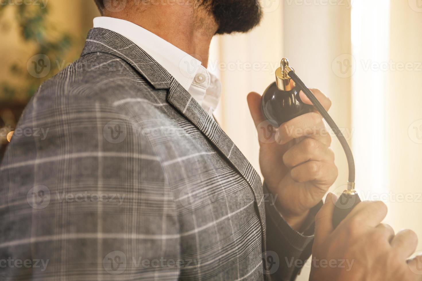 Man is using atomizer nozzle with perfume photo