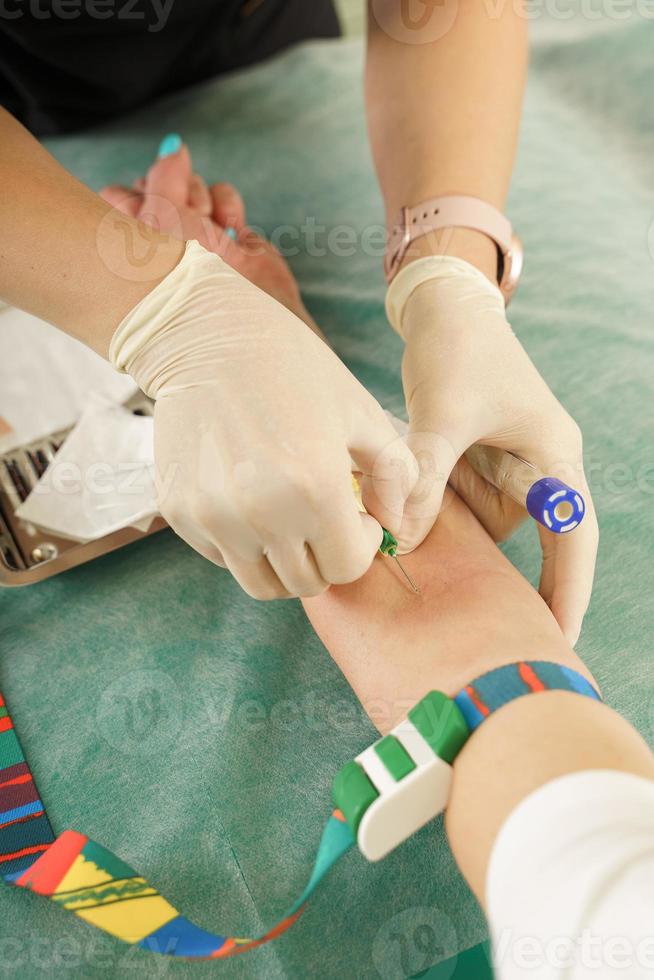 Enfermera recogiendo muestra de sangre del paciente para prueba o donación. foto