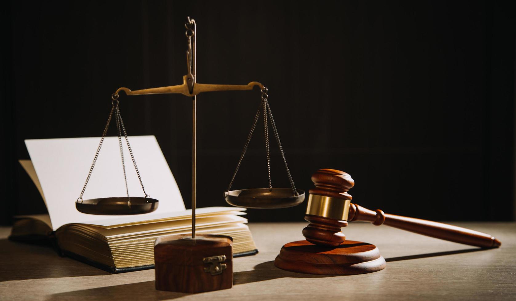 Justice and law concept.Male judge in a courtroom with the gavel, working with, computer and docking keyboard, eyeglasses, on table in morning light photo