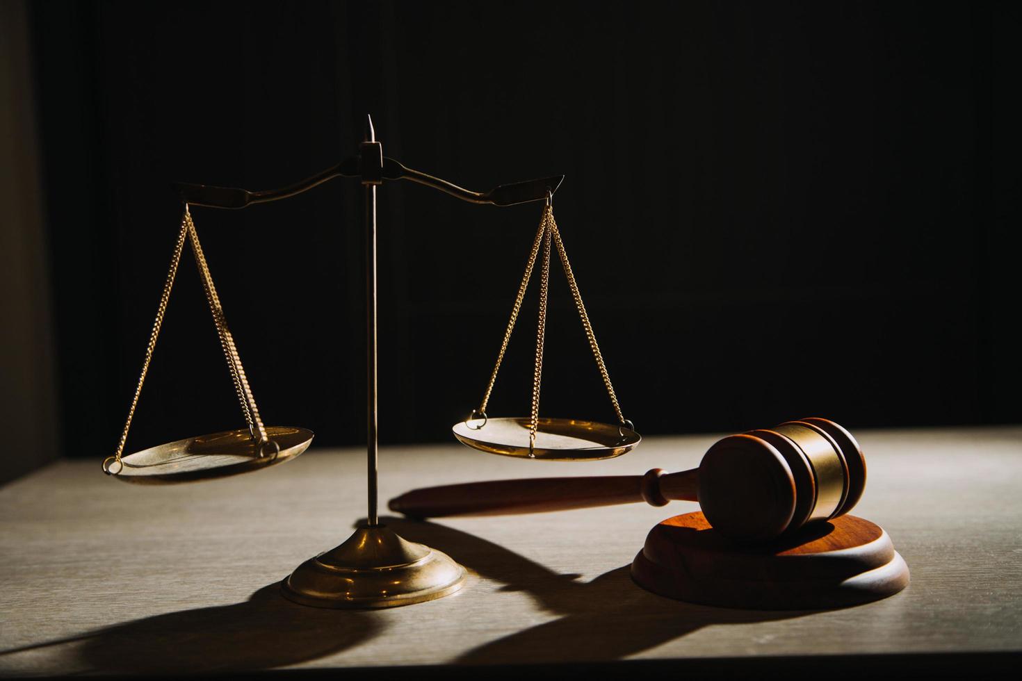 Justice and law concept.Male judge in a courtroom with the gavel, working with, computer and docking keyboard, eyeglasses, on table in morning light photo