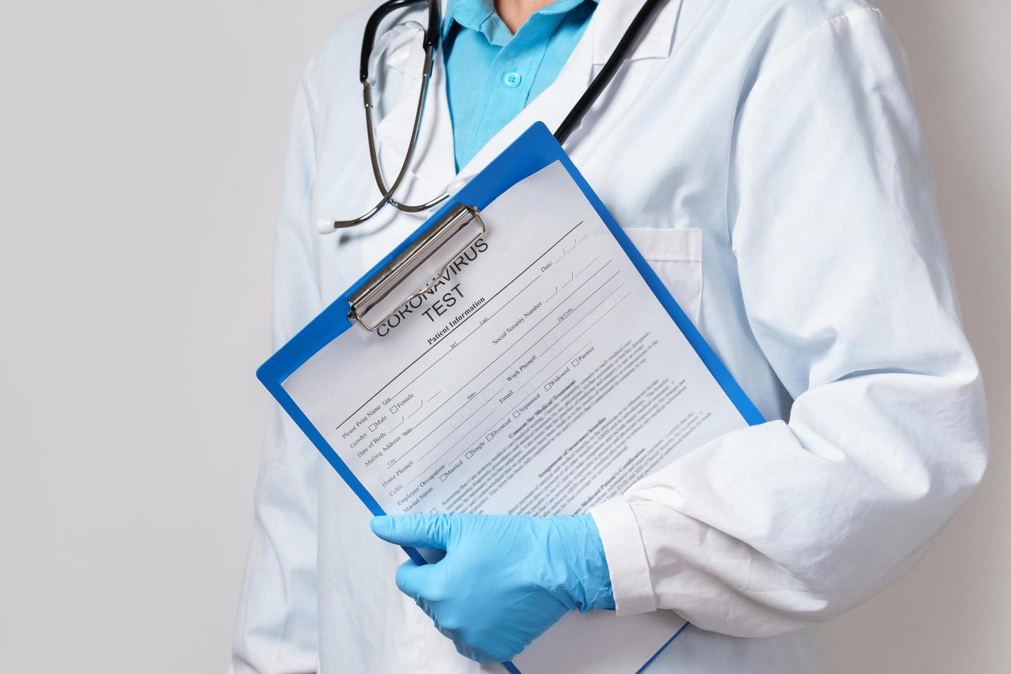 médico sosteniendo una carpeta con un formulario de prueba de coronavirus foto