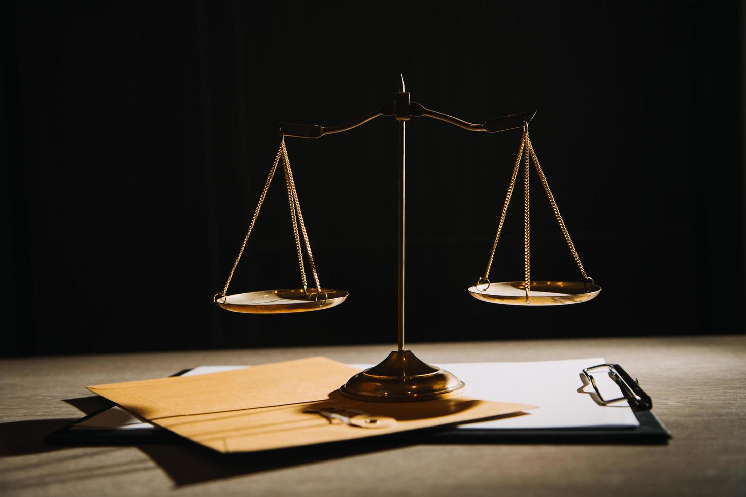 Justice and law concept.Male judge in a courtroom with the gavel, working with, computer and docking keyboard, eyeglasses, on table in morning light photo