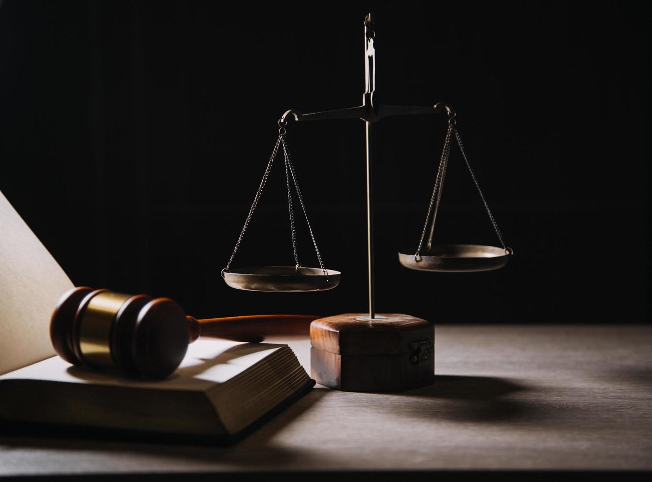 Justice and law concept.Male judge in a courtroom with the gavel, working with, computer and docking keyboard, eyeglasses, on table in morning light photo