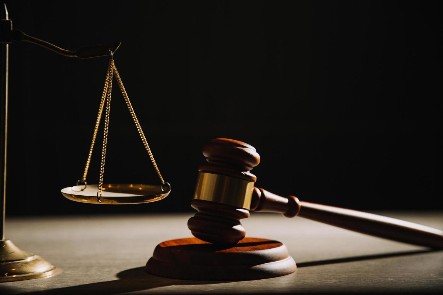 Justice and law concept.Male judge in a courtroom with the gavel, working with, computer and docking keyboard, eyeglasses, on table in morning light photo