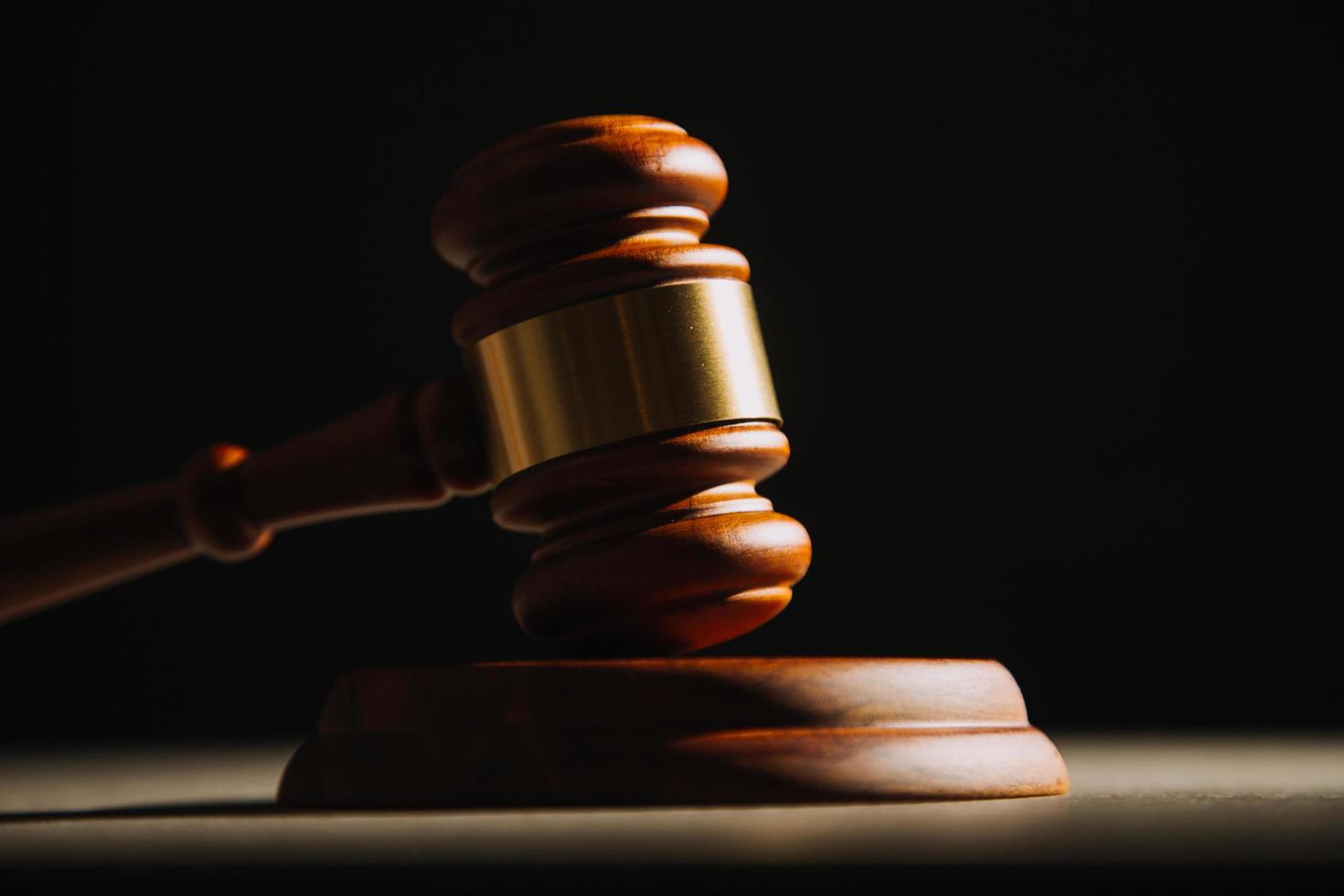 Justice and law concept.Male judge in a courtroom with the gavel, working with, computer and docking keyboard, eyeglasses, on table in morning light photo