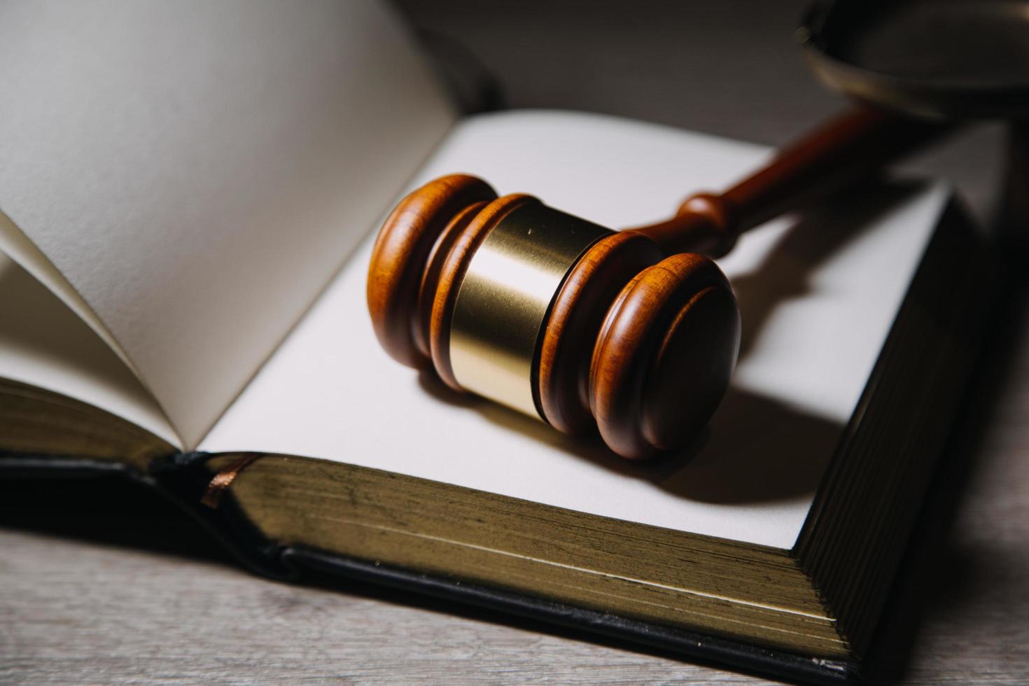 Justice and law concept.Male judge in a courtroom with the gavel, working with, computer and docking keyboard, eyeglasses, on table in morning light photo