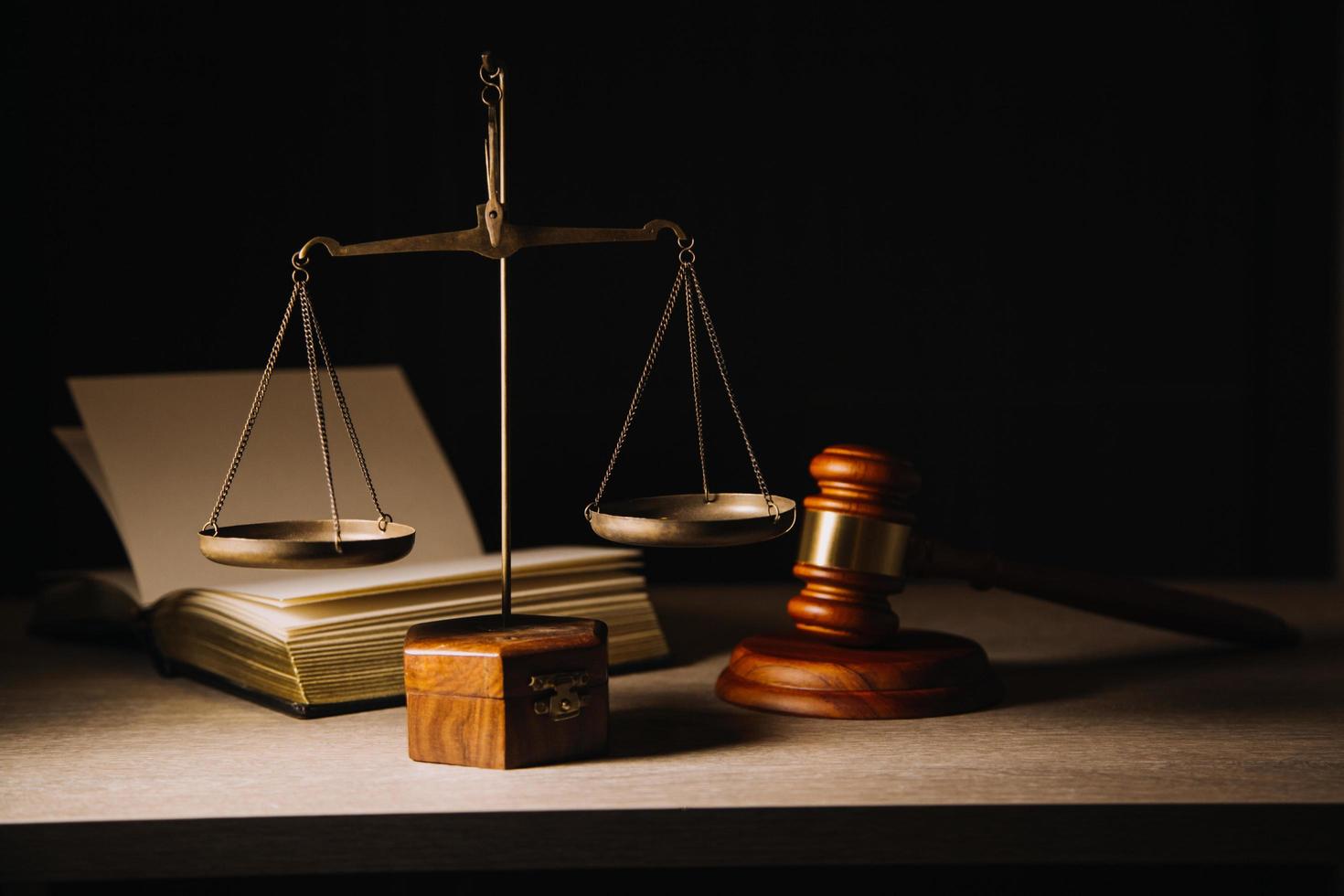 Justice and law concept.Male judge in a courtroom with the gavel, working with, computer and docking keyboard, eyeglasses, on table in morning light photo