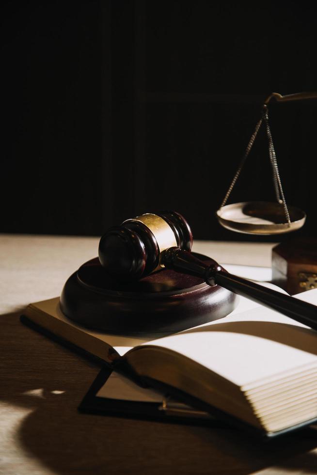 Justice and law concept.Male judge in a courtroom with the gavel, working with, computer and docking keyboard, eyeglasses, on table in morning light photo