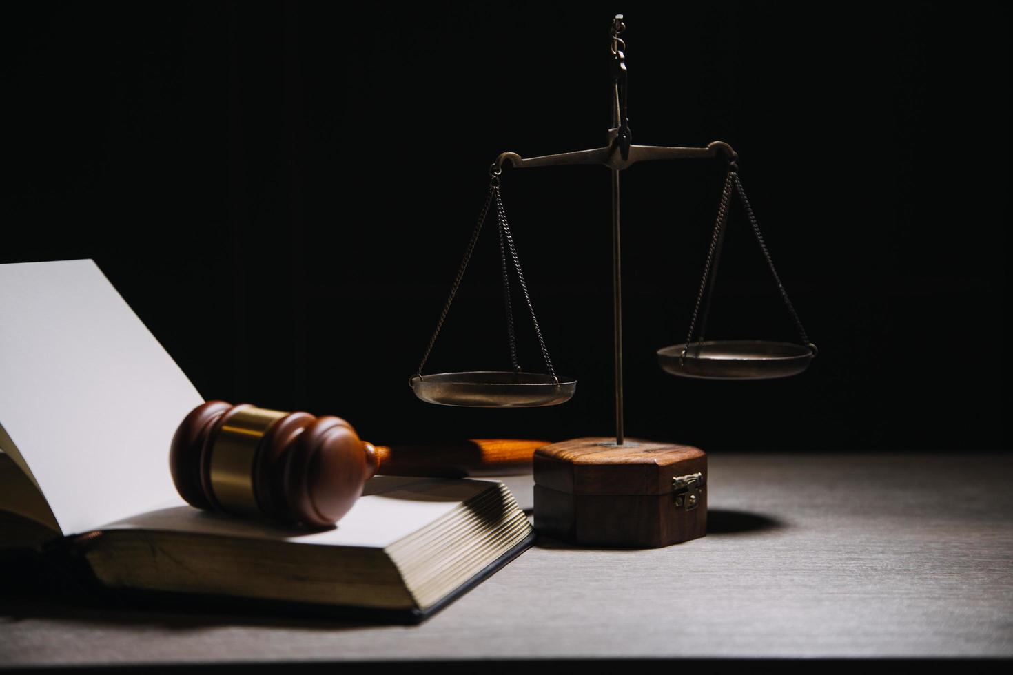 Justice and law concept.Male judge in a courtroom with the gavel, working with, computer and docking keyboard, eyeglasses, on table in morning light photo