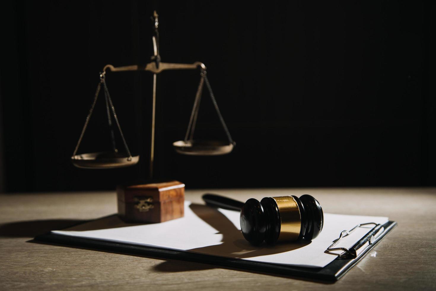 Justice and law concept.Male judge in a courtroom with the gavel, working with, computer and docking keyboard, eyeglasses, on table in morning light photo