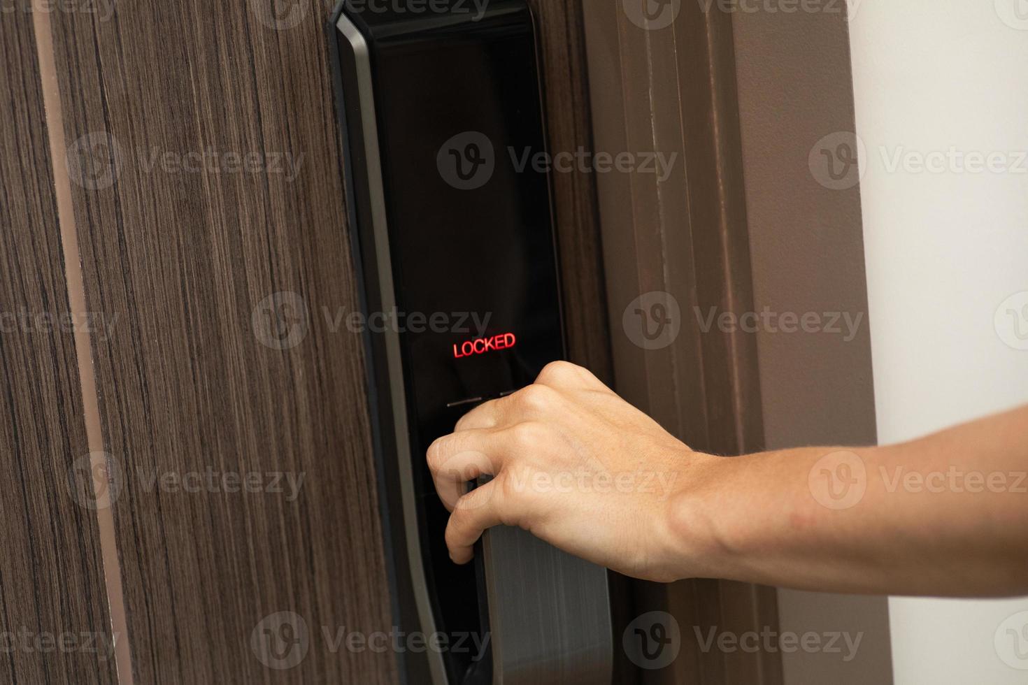 Hand and digital smart code lock into the modern apartment photo