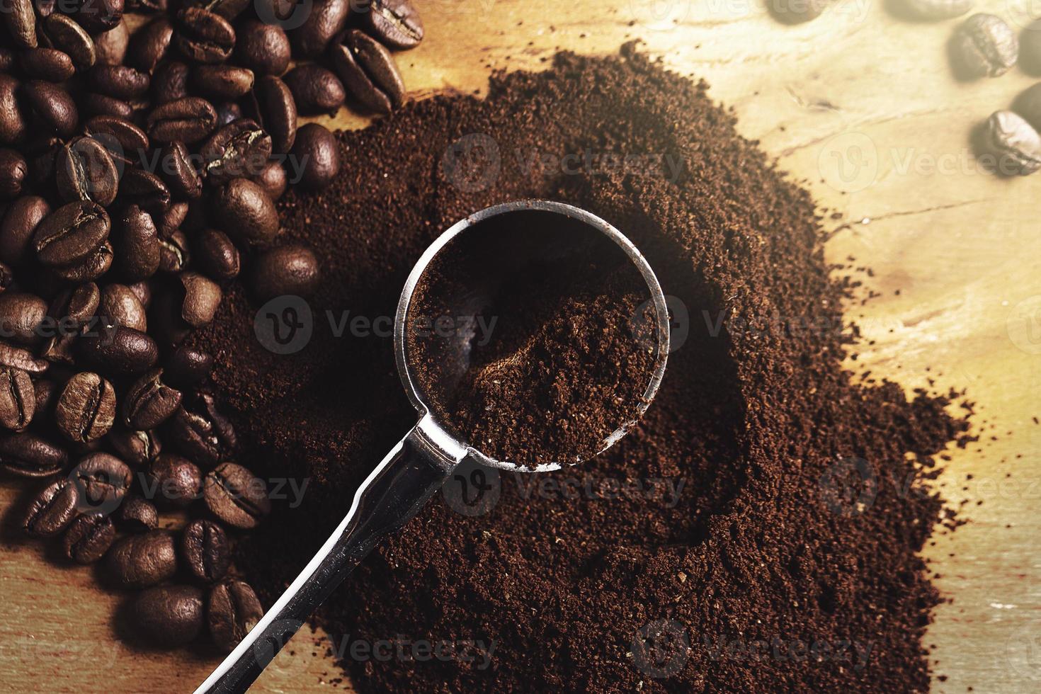 Closeup of steel spoon, grounded coffee and beans photo