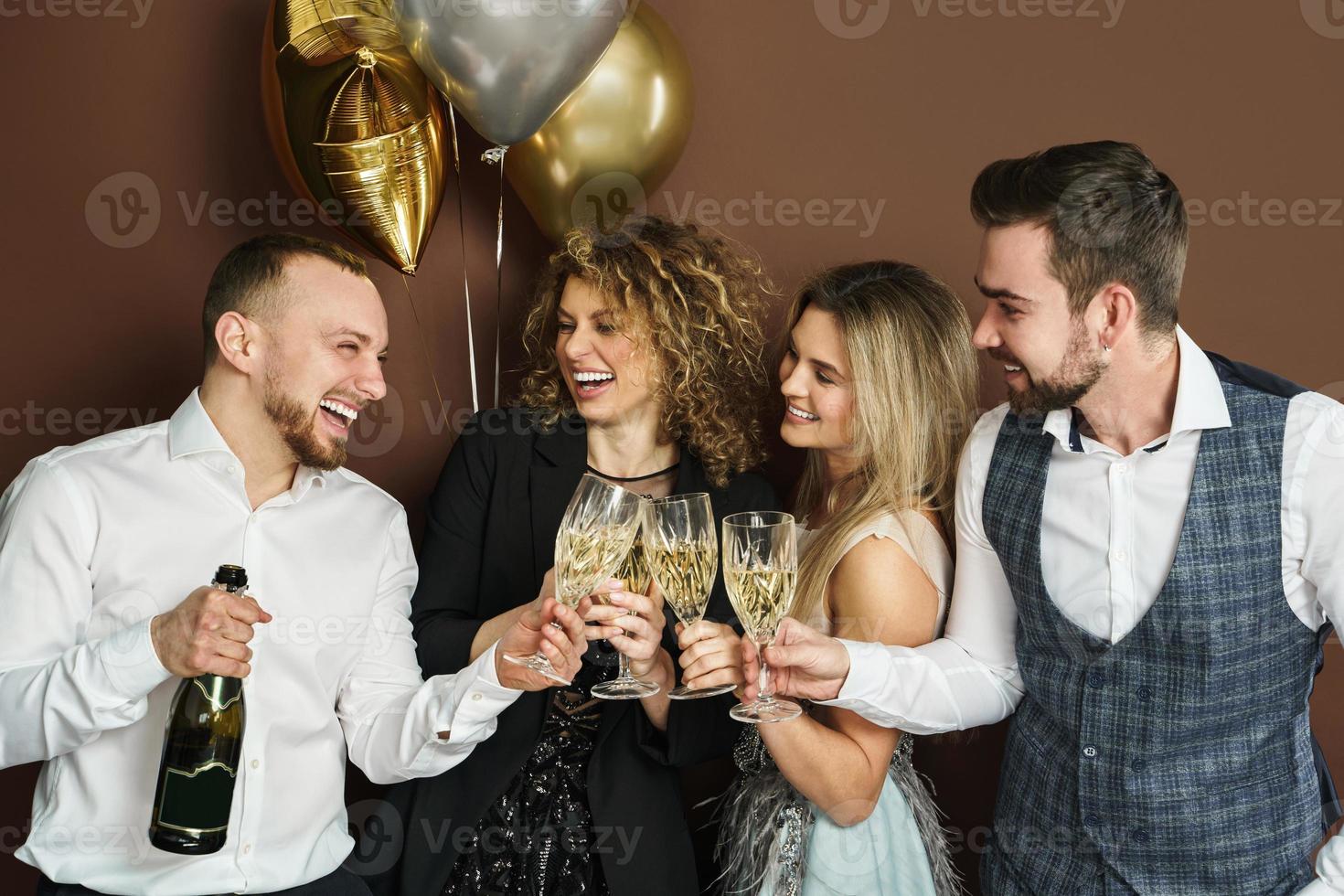 Well dressed party people celebrating  holiday or event and drinking sparkling wine photo