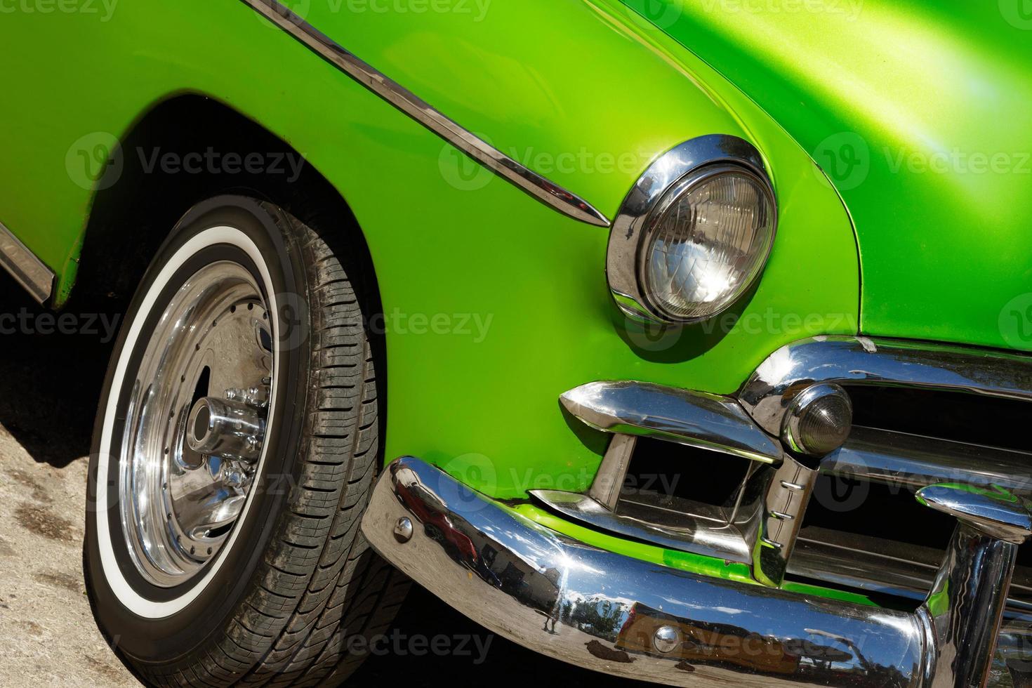 Shiny vintage green car parked on street photo