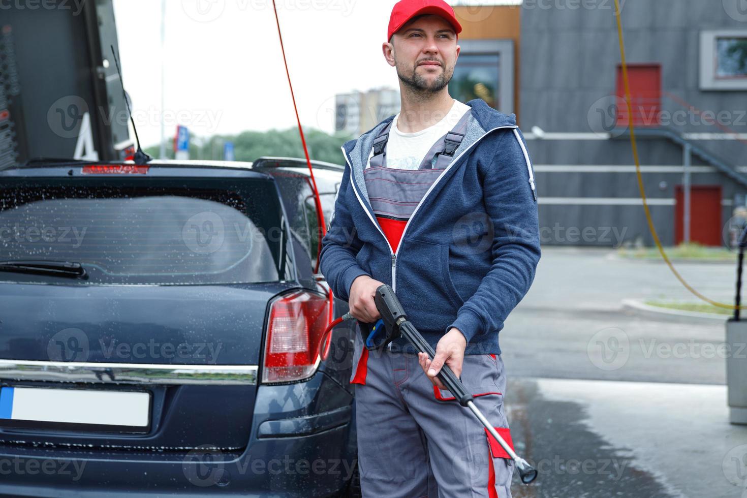 Car wash worker is washing client's car photo