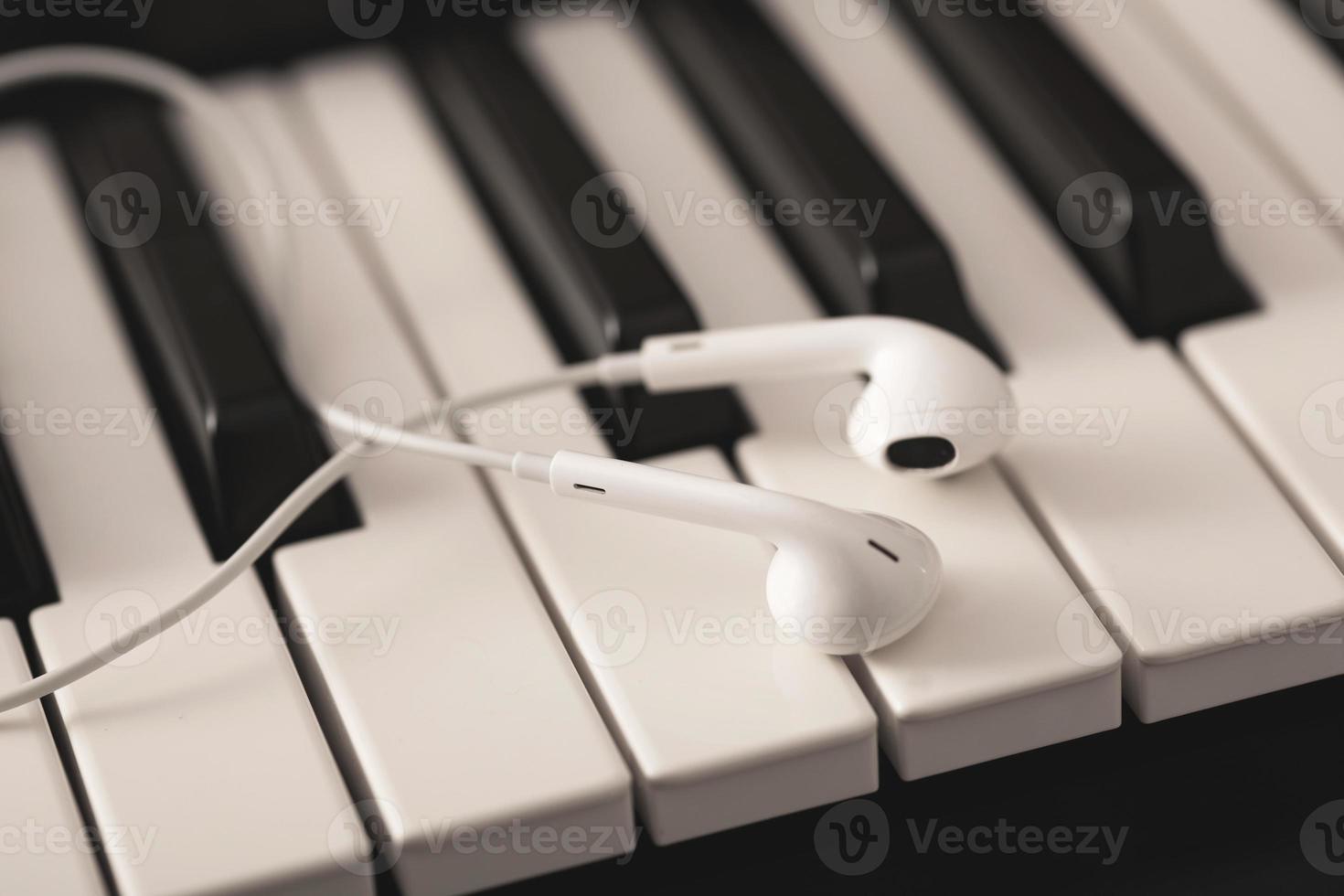 Closeup of earphones over piano or synthesizer keyboard photo