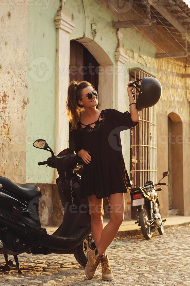 Woman driving scooter by the old city streets photo