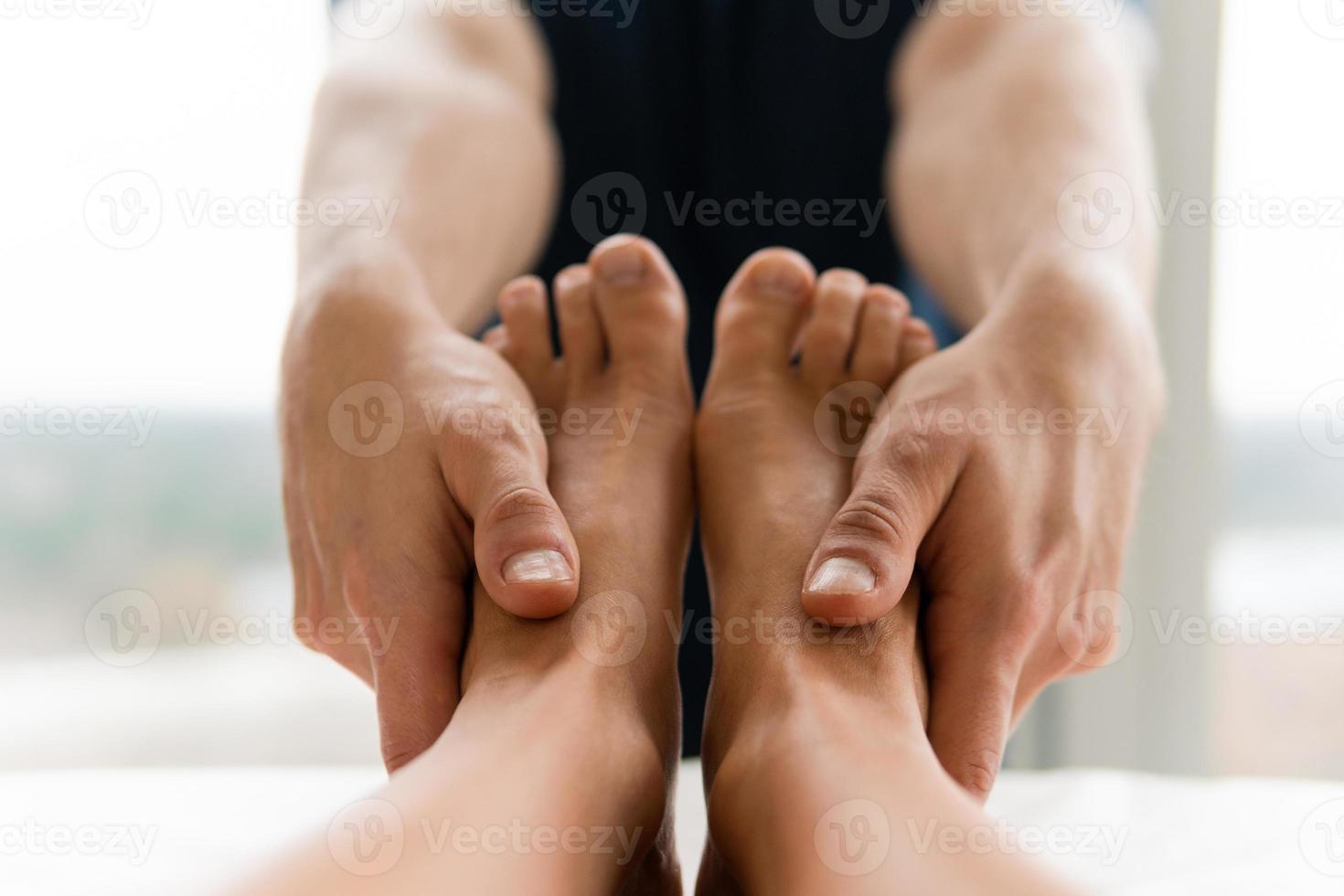 Masseur man during female foot massage photo