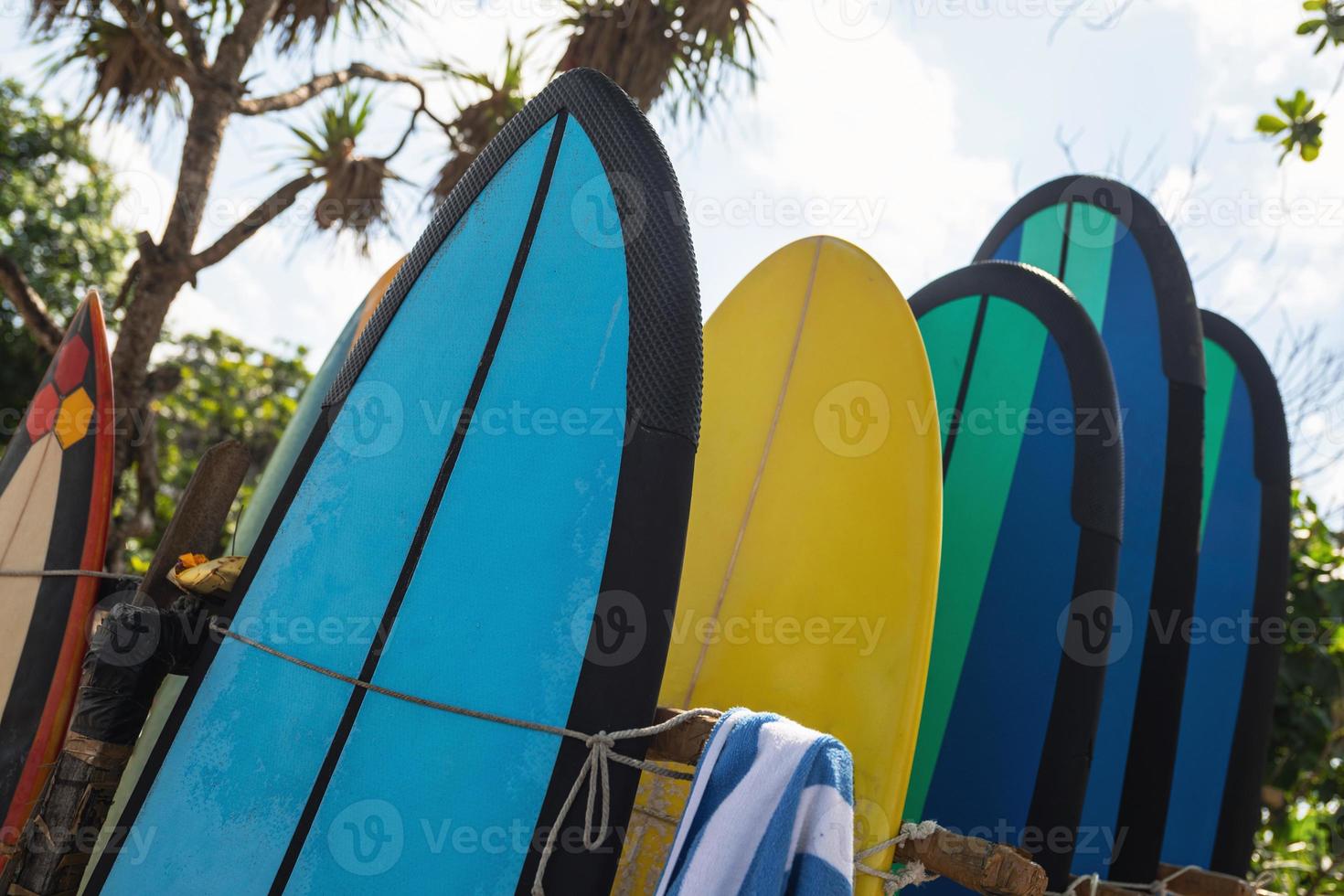 pila de diferentes tablas de surf para alquilar en la playa foto