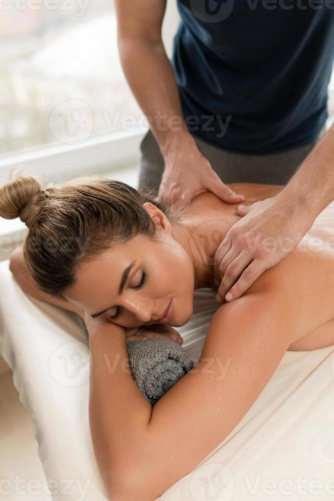 Masseur man doing back massage for his client photo