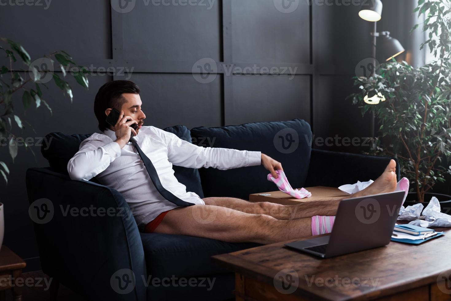 Lazy businessman without pants working from home photo