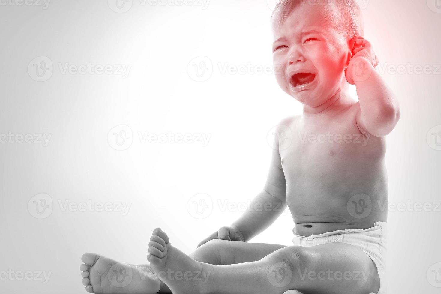 Crying baby suffering from a ear pain photo