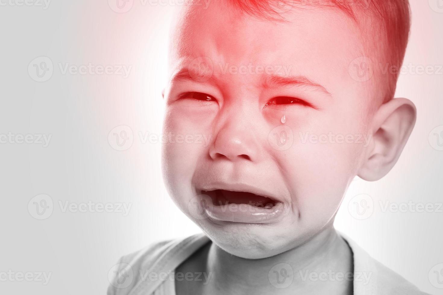 pequeño bebé llorando que sufre de dolor de cabeza foto