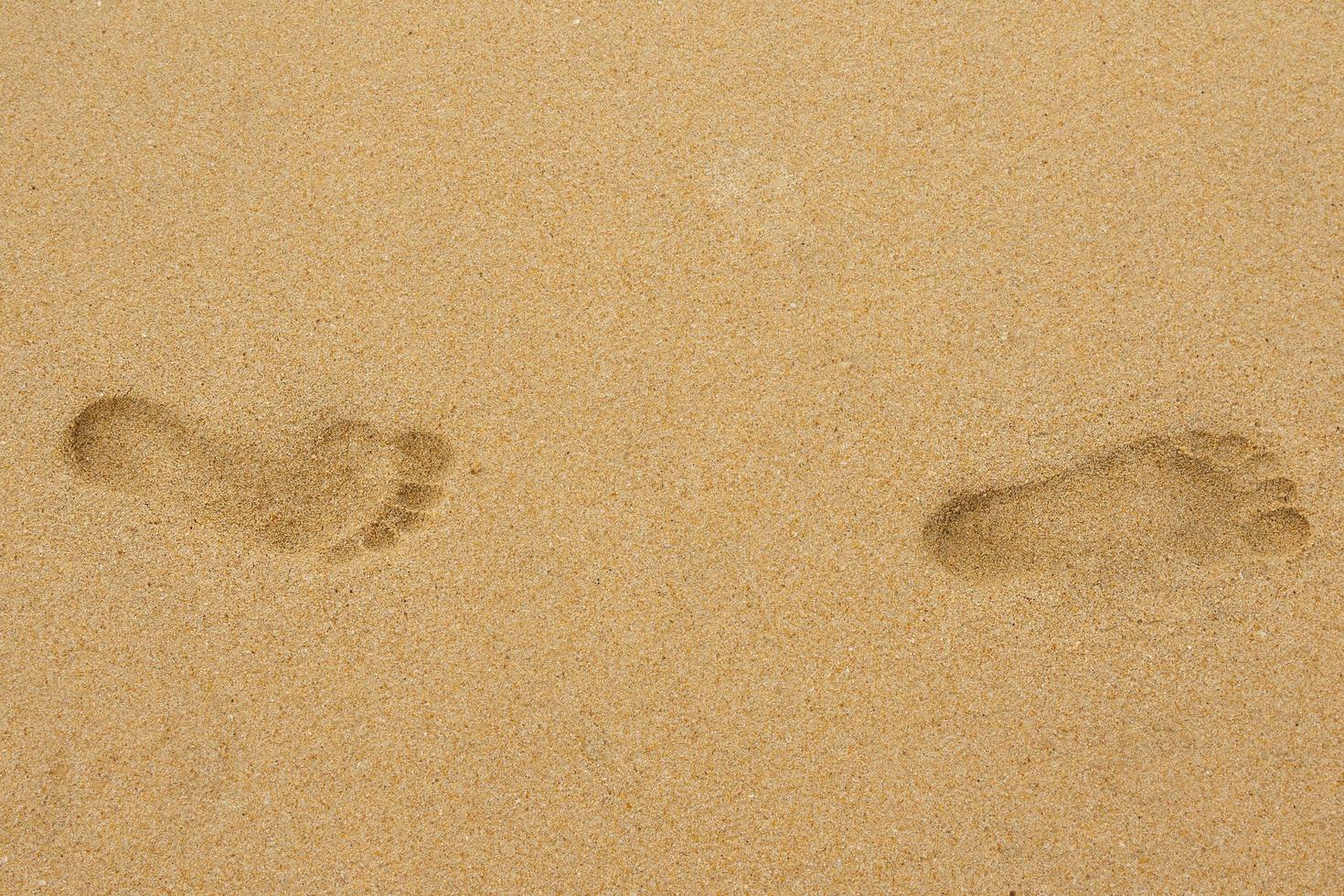 Two foot prints on the sandy sand photo