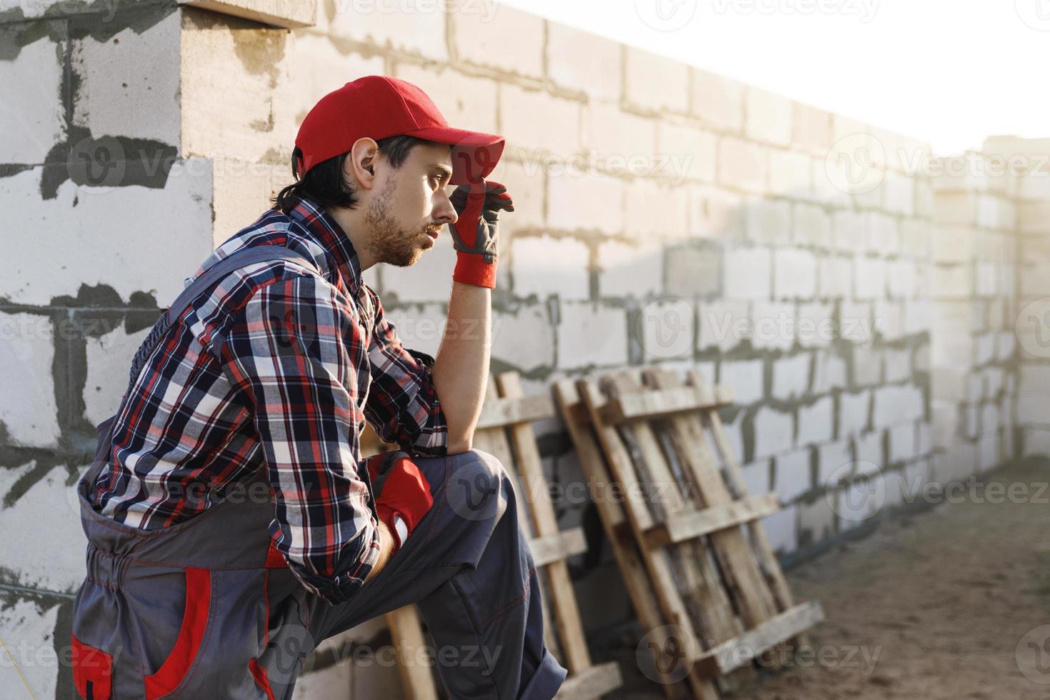 Professional bricklayer man at the construction site photo
