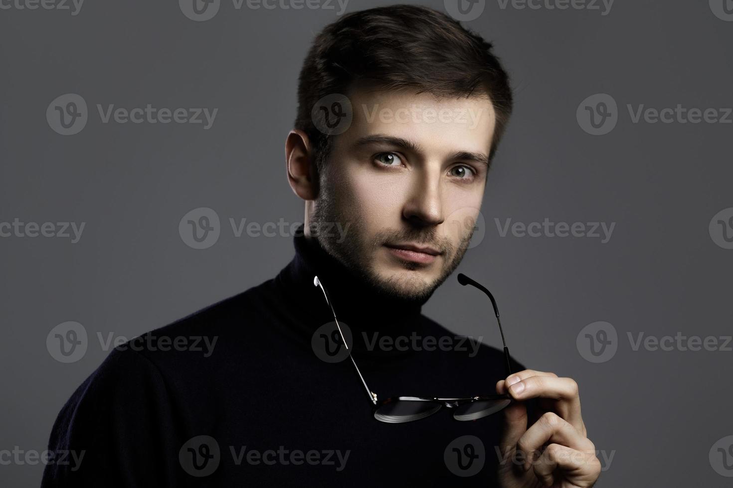 Young intelligent man wearing turtleneck and eyeglasses photo