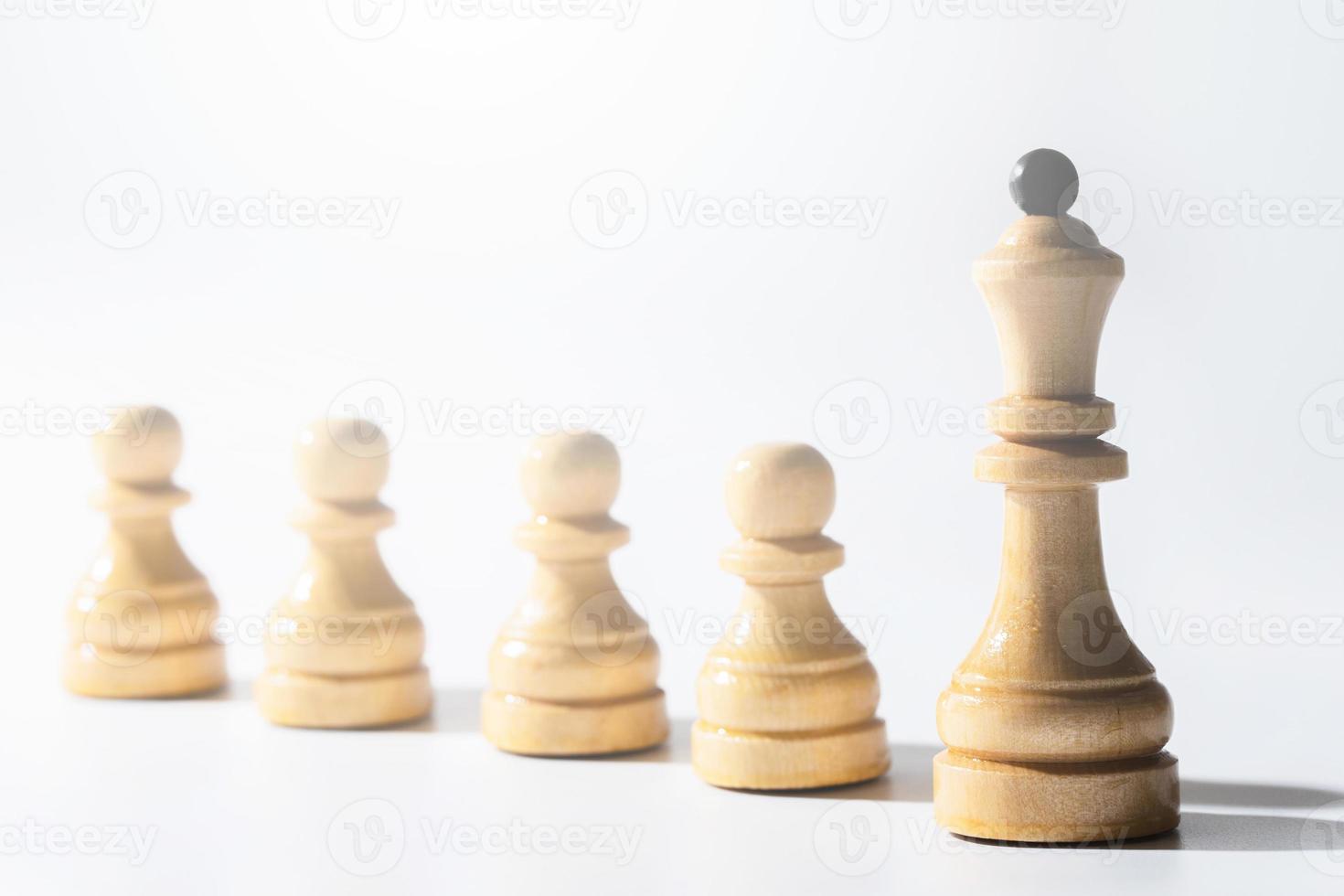 Row of chessmen with queen in the lead. photo