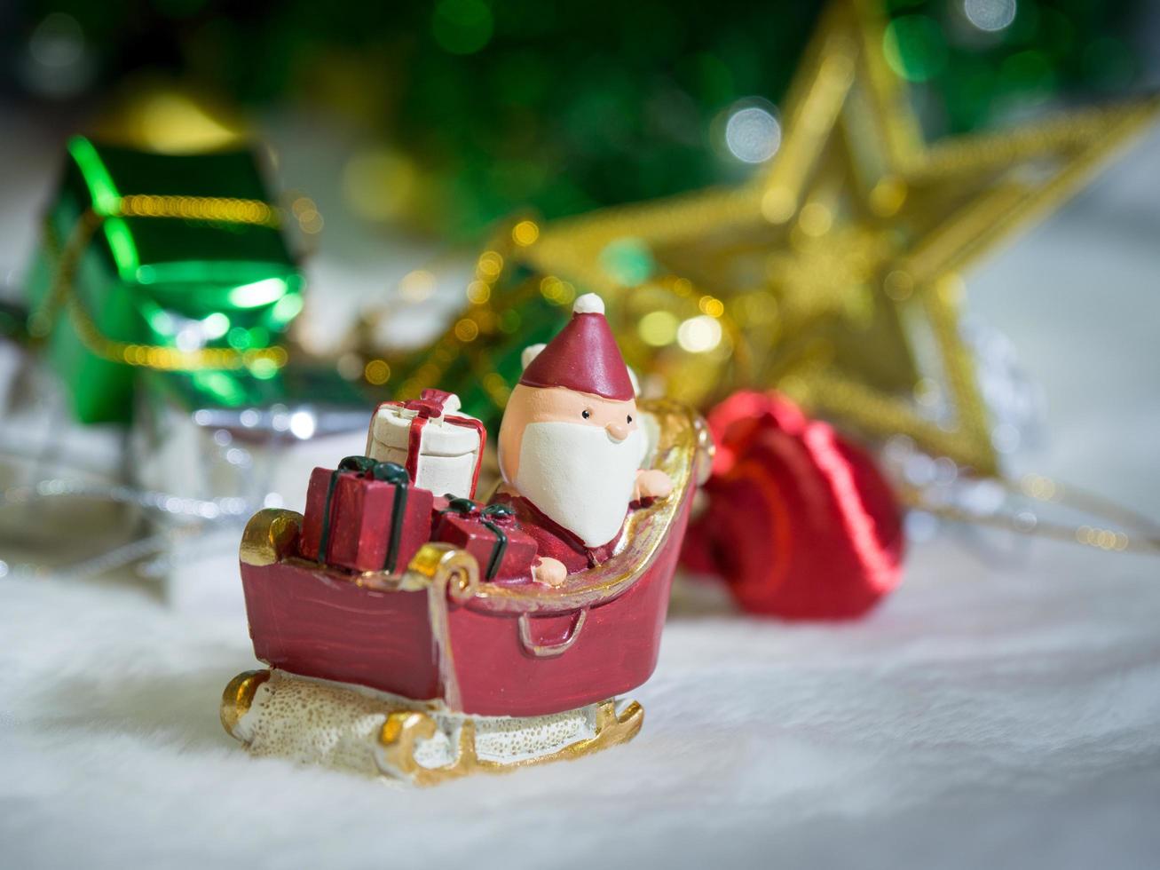 Happy Santa Claus with gifts box on the snow sled the background is Christmas decor.Santa Claus and Christmas decor on the snow. Merry Christmas and happy new year concept photo