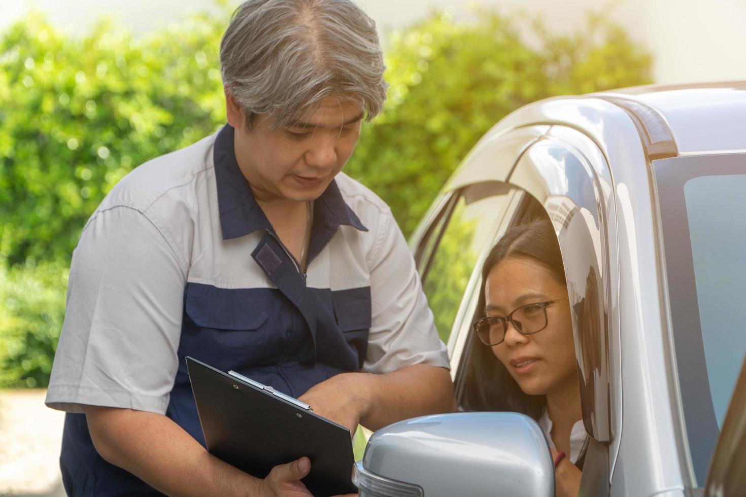 The car mechanic is describing the details of the rehearsal. After checking the cause of the broken car. For women, car owners to listen for understanding photo