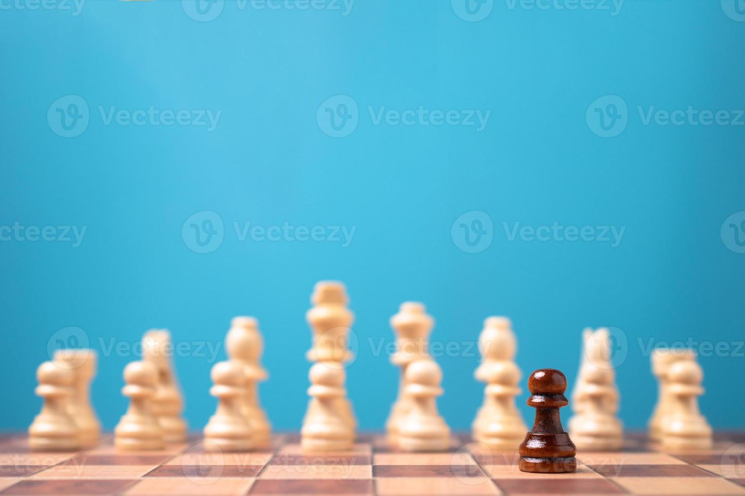 Brown chessman standing in front of white chess, Concept of a new startup must have courage and challenge in the competition, leadership and business vision for a win in business games photo