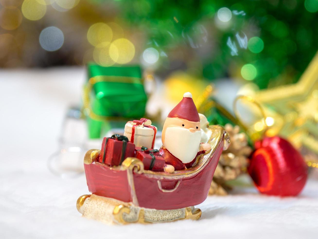 feliz santa claus con caja de regalos en el trineo de nieve el fondo es decoración navideña.santa claus y decoración navideña en la nieve. feliz navidad y feliz año nuevo concepto foto