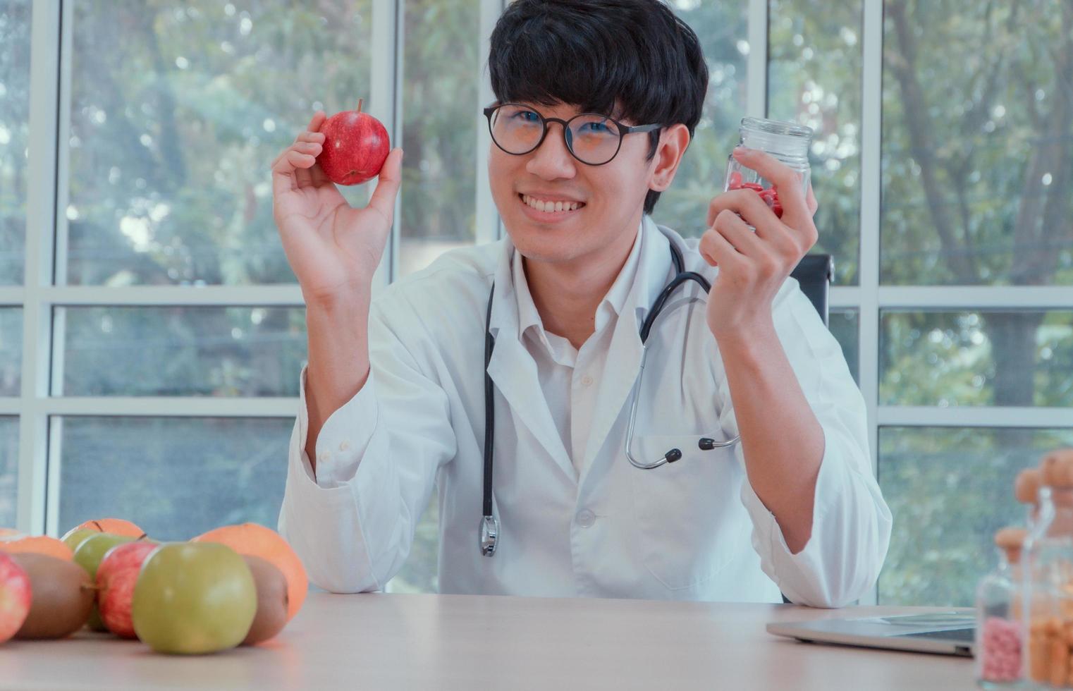 Doctors or nutritionists hold apples and Vitamin bottles In the clinic. Good health starts with you. Useful food concept. photo