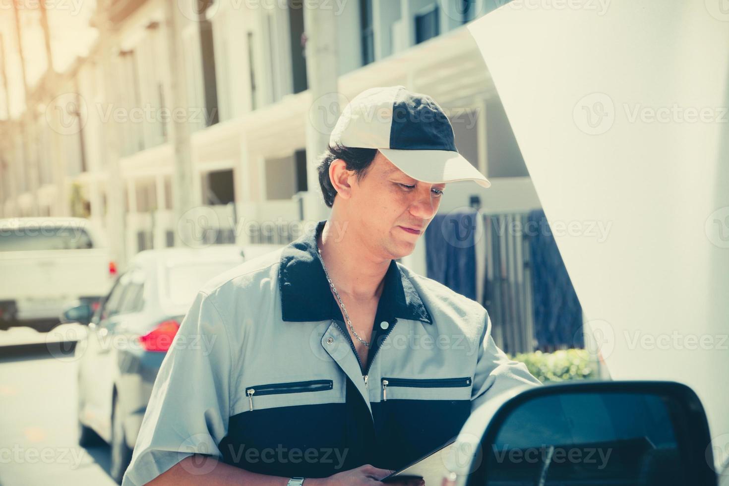 Auto repairman checks the engine before traveling on a long holiday. photo