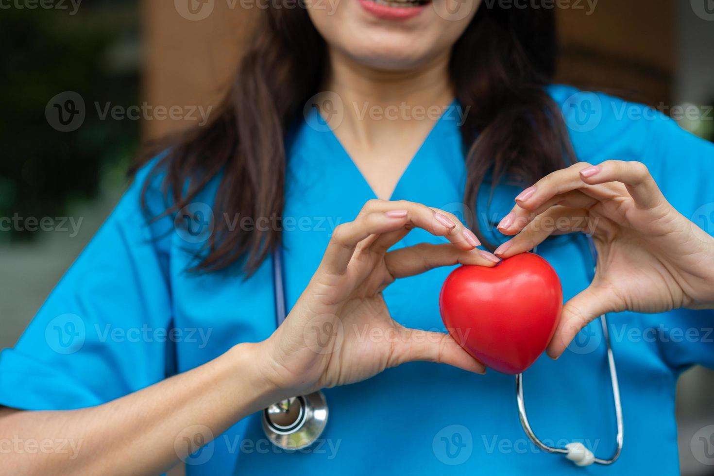 médico de enfermedades cardiovasculares o cardiólogo con estetoscopio con corazón rojo, atención médica y concepto de servicio de personal médico. foto