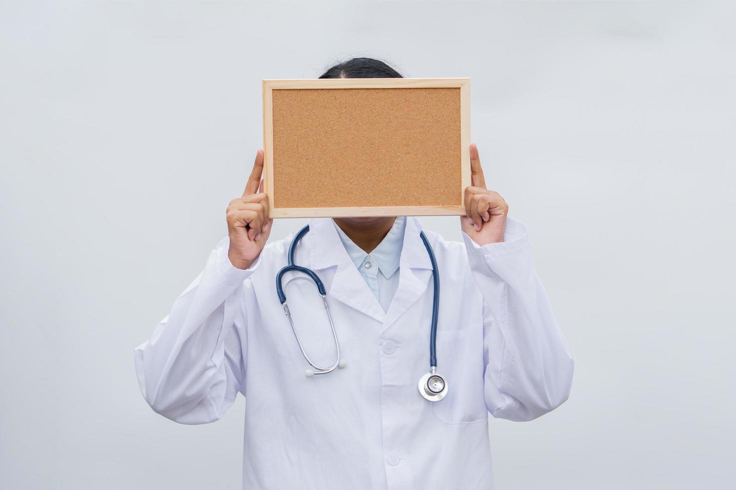 profession doctor in white coat over white isolated background with white blank board. Concept of healthcare, science and medicine concept photo