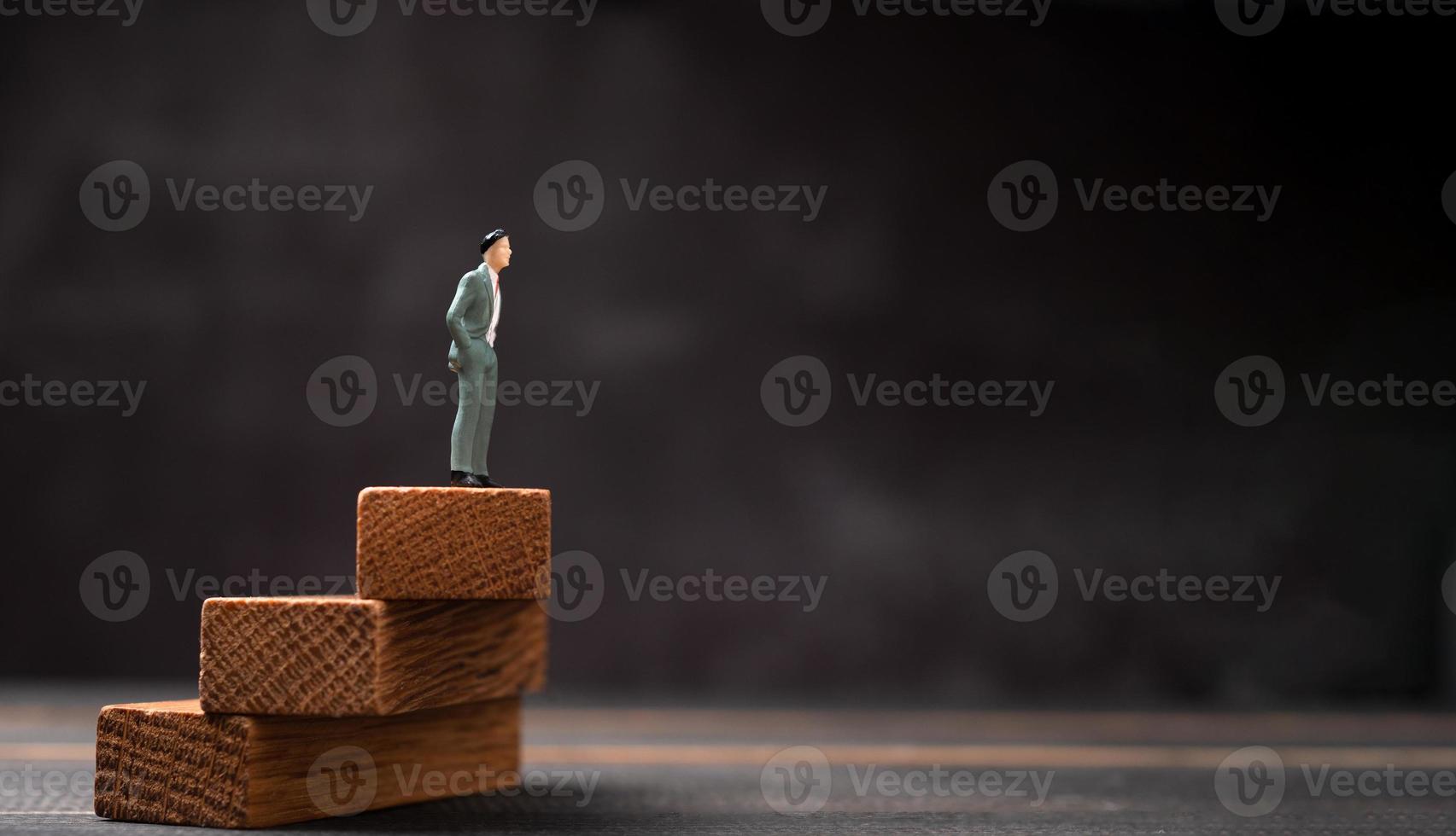 Figure businessman standing on a wooden stand and looking to the future. The concept of Leaders in good organizations must have a vision. That will take the organization and the team moving forward photo