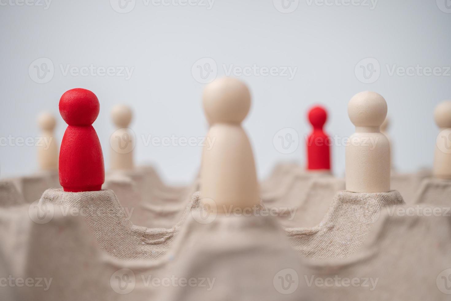 A wooden figure standing with team to influence and empowerment. Concept of leadership, successful competition winner and Leader with influence and Social distancing for a new normal lifestyle photo